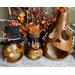 This shows three ghostly pumpkin gourds on a Halloween table display. There are three sizes, each with stitched scars on their faces.
